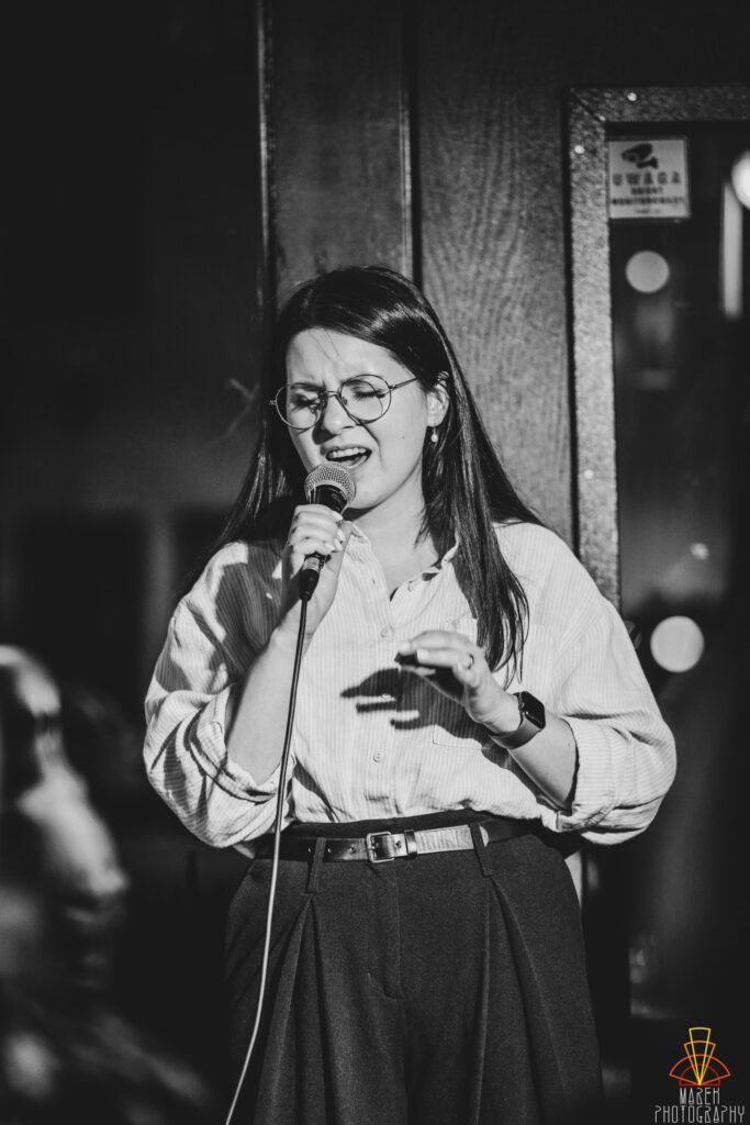 Sara Kosińska emocjonalnie śpiewająca z mikrofonem w ręce
